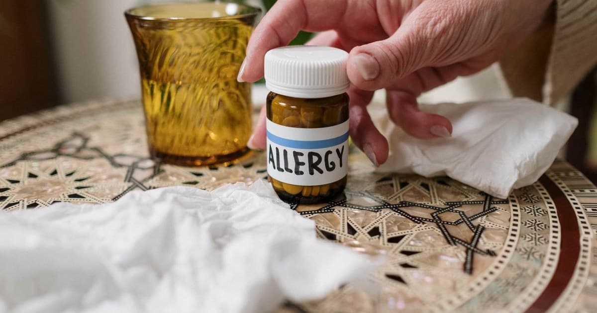 테이블 위에 놓인 ALLERGY 라벨 약병과 흰 티슈