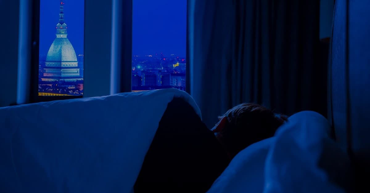 야간 도시 야경이 보이는 어두운 침실 창가