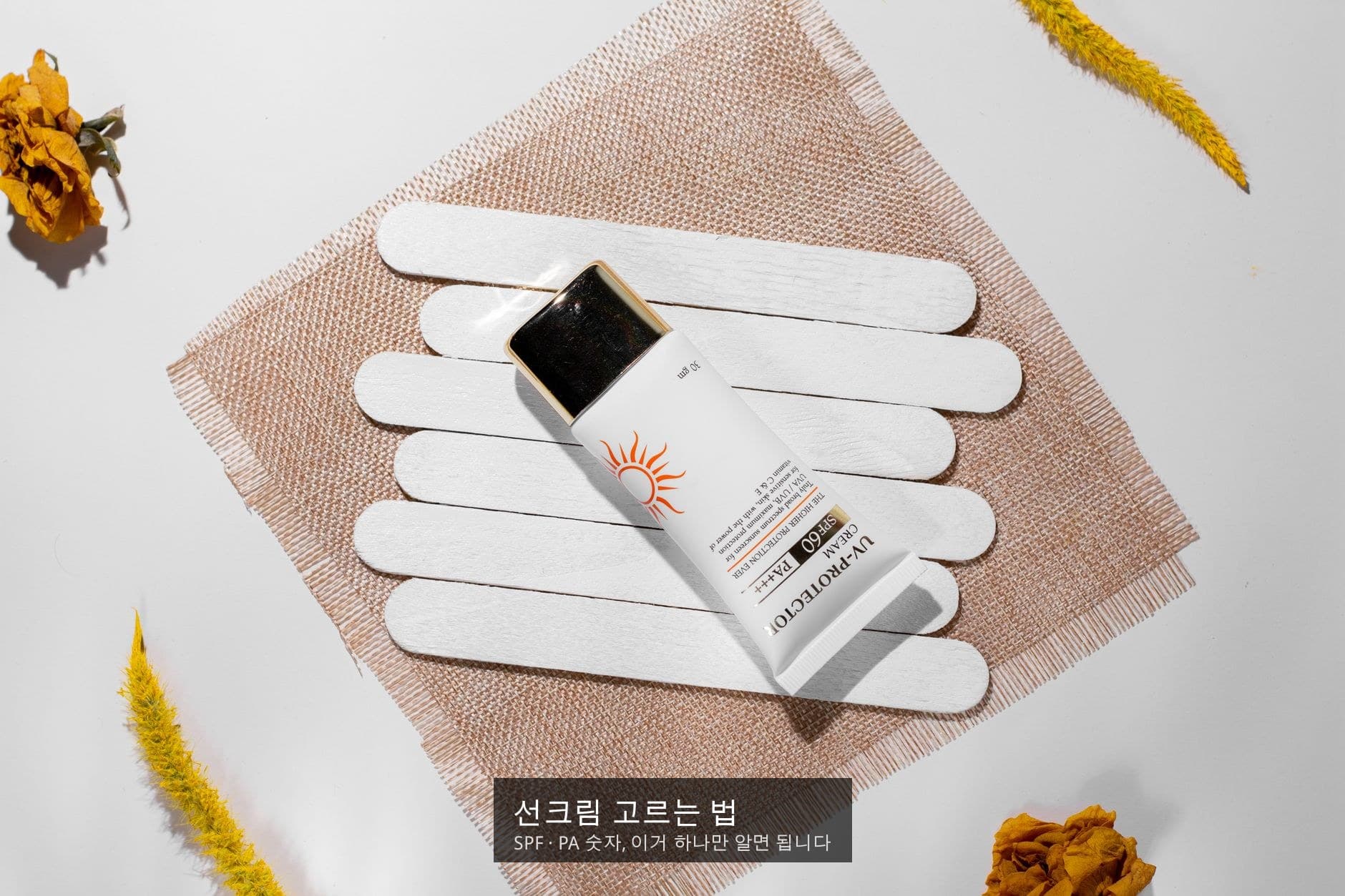 선크림 튜브와 꽃잎 등 자연 소재가 놓인 플랫레이